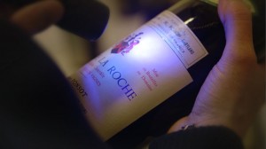 An investigator takes a close look at a fake wine label in "Sour Grapes."