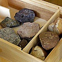 A box full of stones from the Kreydenweiss family vineyards in Alsace: Dark-gray granite, pale-tan schist, reddish sandstone.